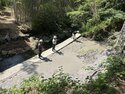  田んぼに送る用水管が崩れ土砂が石積みの下を抜けて川に流れてしまった。巨大な空洞が発生したことで石積み崩壊のリスクをCLSMで解消